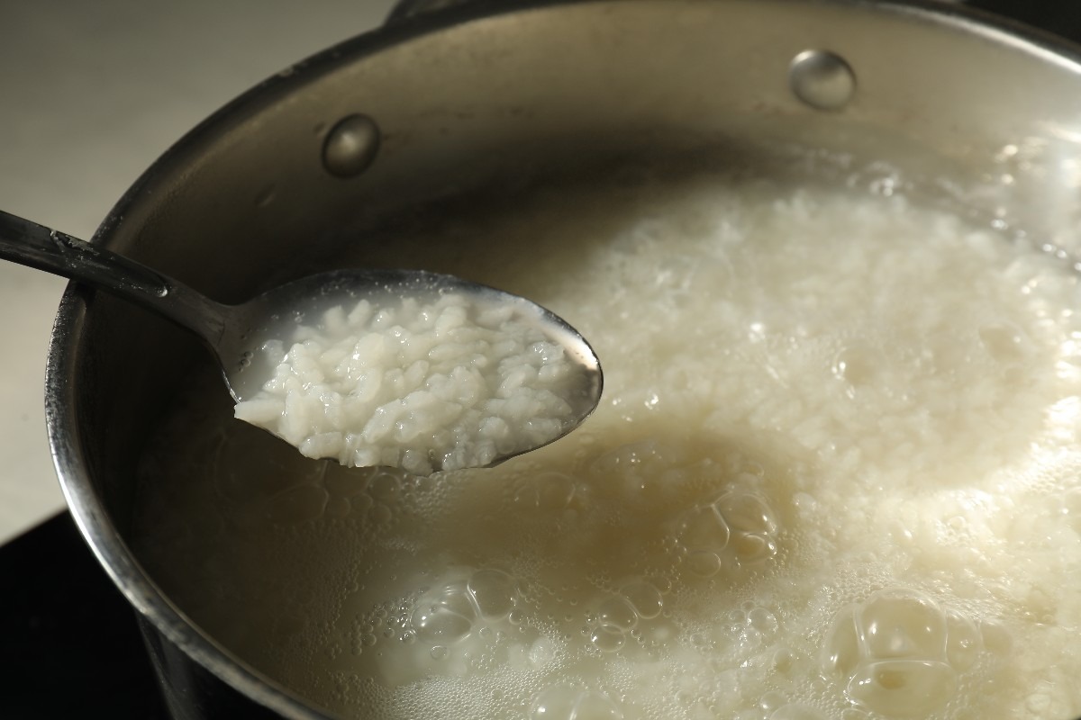 Cucchiaio che solleva riso cotto nel brodo