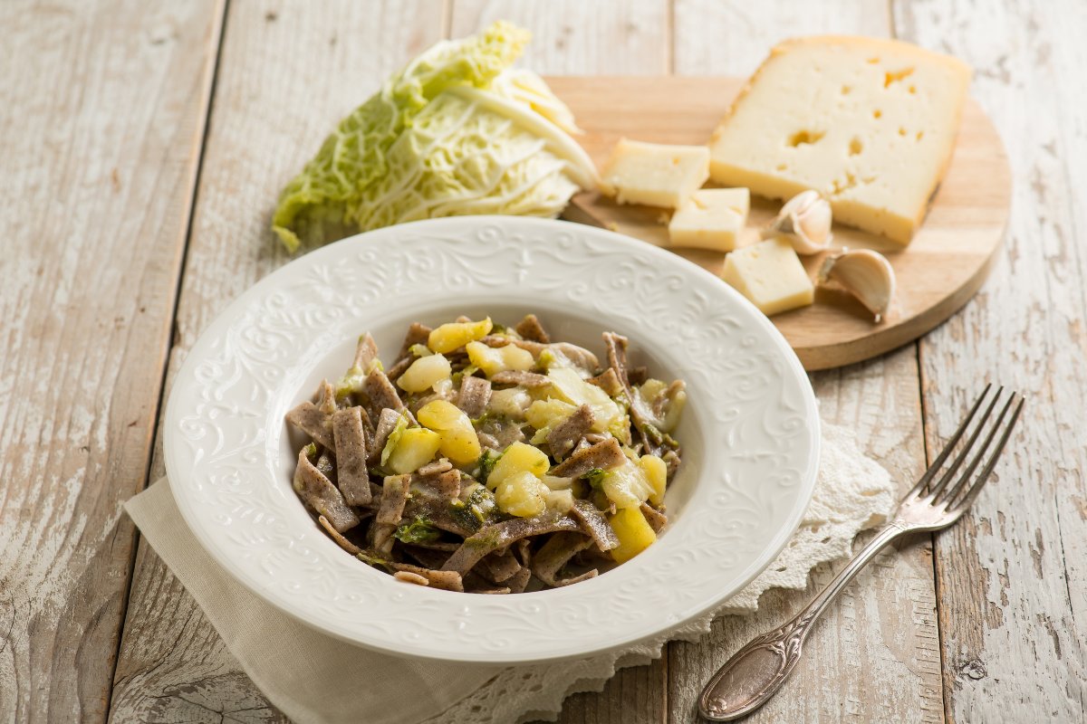 Piatto di pizzoccheri alla valtellinese con verza, patate e formaggio