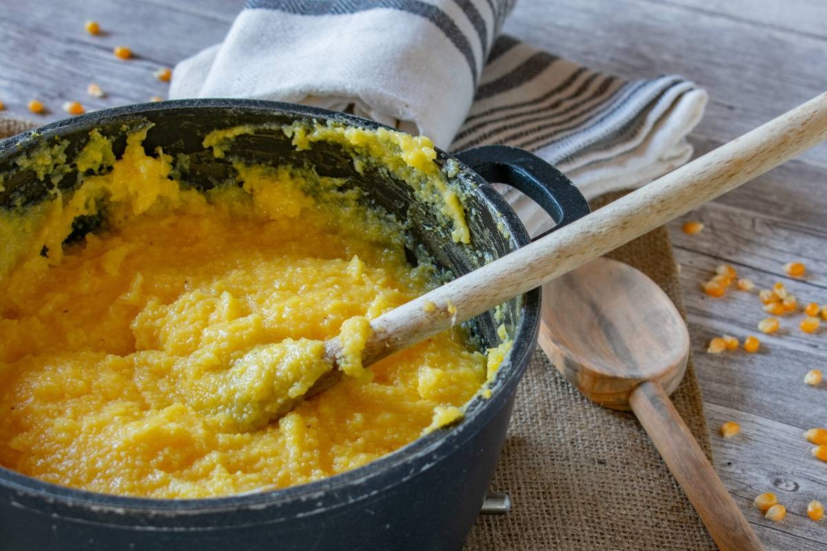 Pentola con polenta appena fatta e cucchiaio di legno