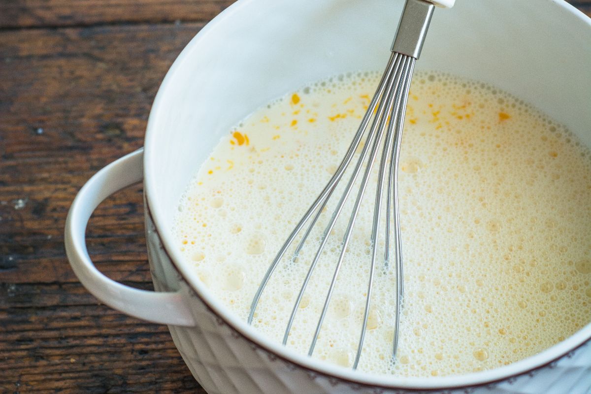 Latte con aromi in una pentola con frusta da cucina