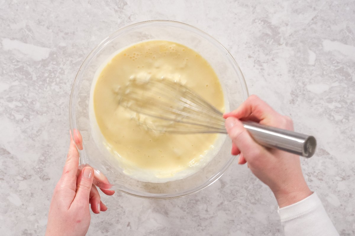 Vista dall'altro mani che mescolano con frusta da cucina impasto torta