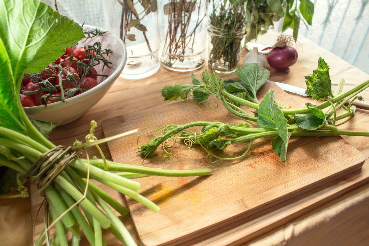 Tagliere di legno con tenerumi di zucchine