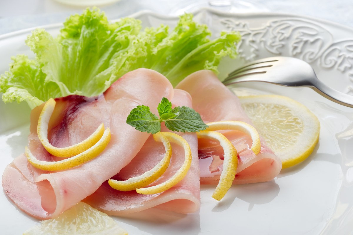 Piatto con insalata e fettine di pesce spada crudo