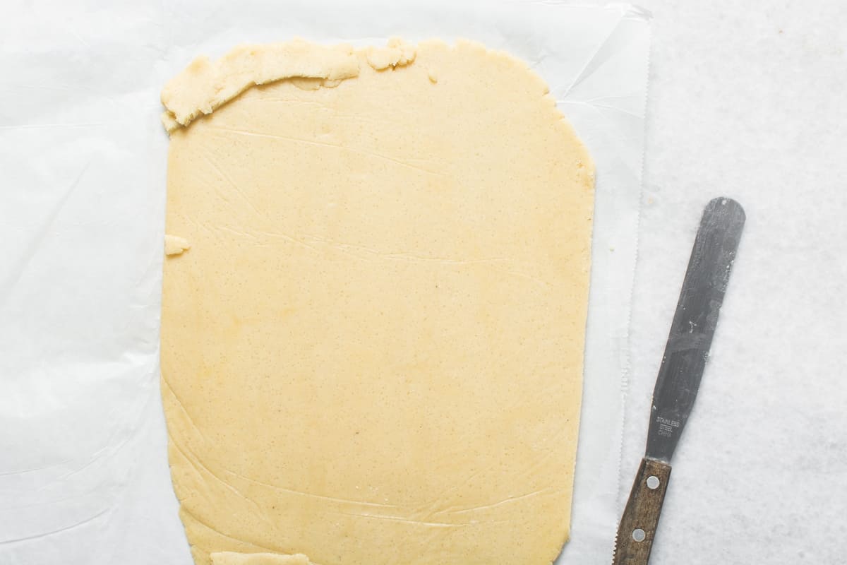 Pasta frolla stesa sottile su piano di lavoro