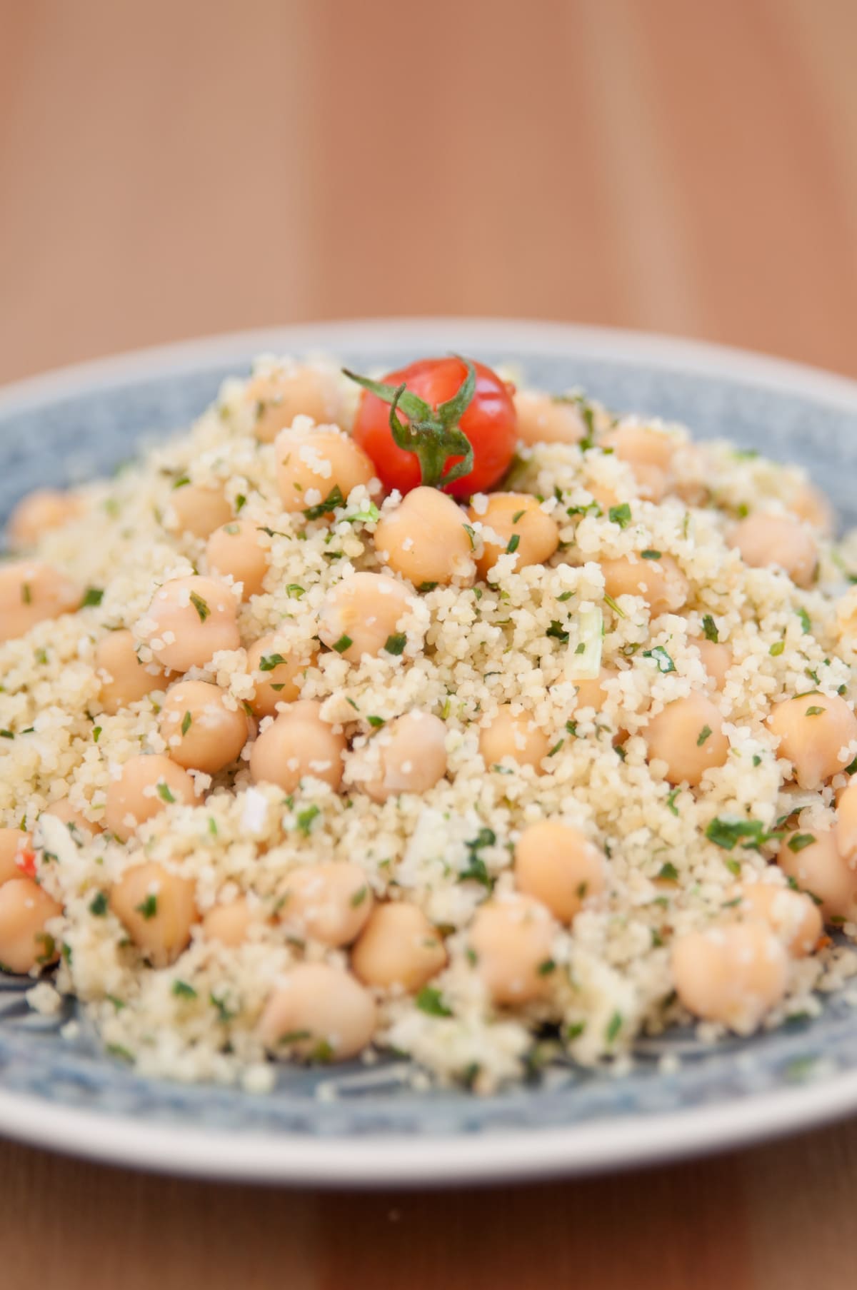 Piatto di cous cous con i ceci decorato con un pomodorino rosso