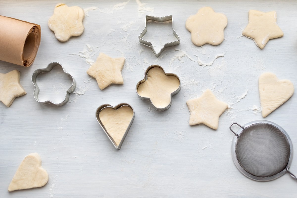 Taglio biscotti di pasta frolla con coppapasta di forme diverse