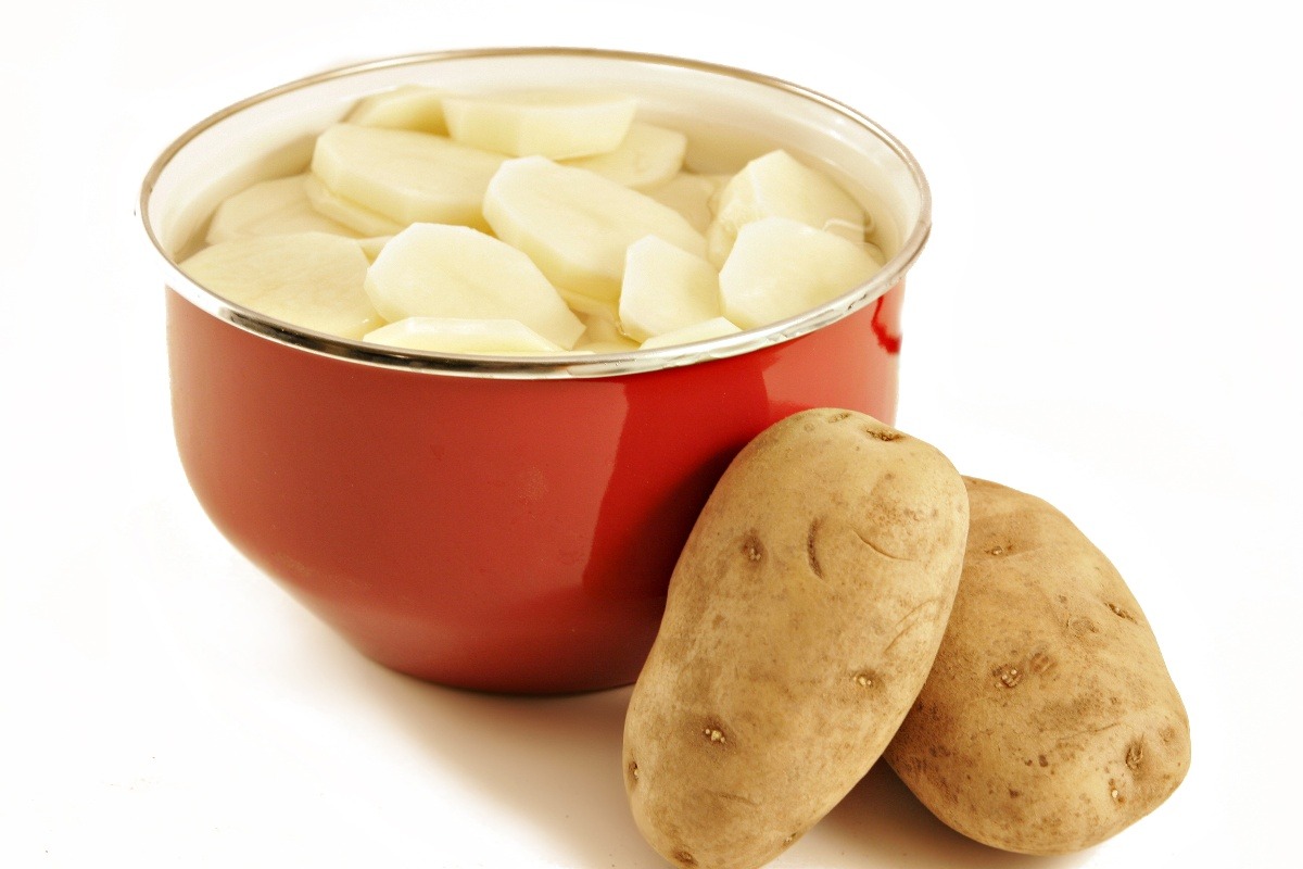Ciotola colma di acqua con all'interno patate a fette
