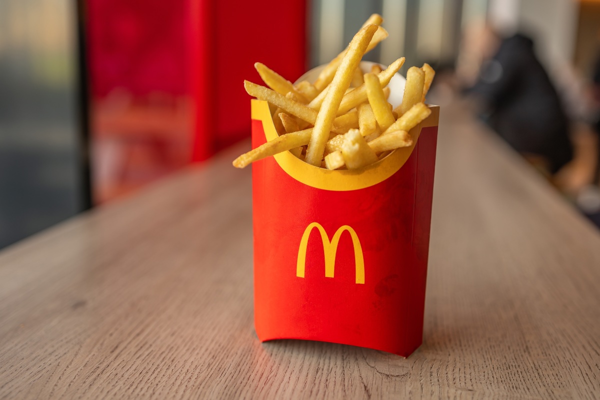 Patatine fritte all'interno del contenitore rosso e giallo appoggiato sul tavolo di un ristorante Mc Donald's