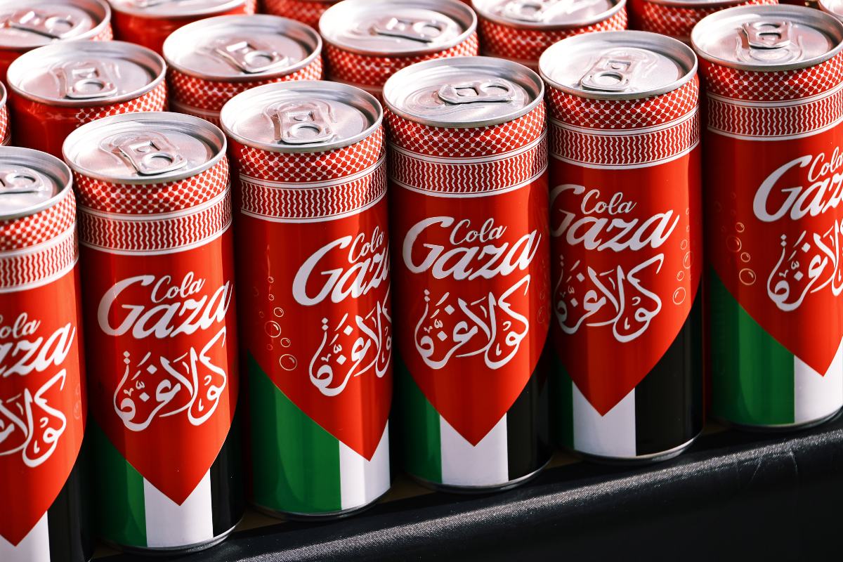 Sopra uno scaffale, alcune lattine di Gaza Cola