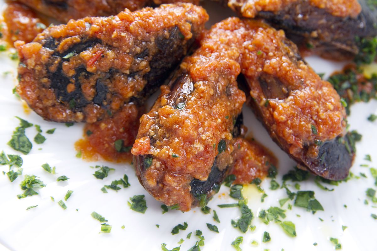 Piatto di cozze ripiene con sugo di pomodoro e prezzemolo
