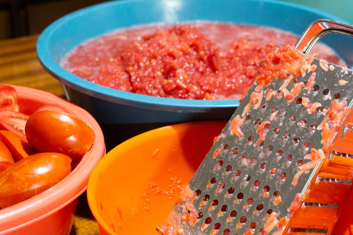 Grattugia sporca di pomodoro grattugiato in una ciotola
