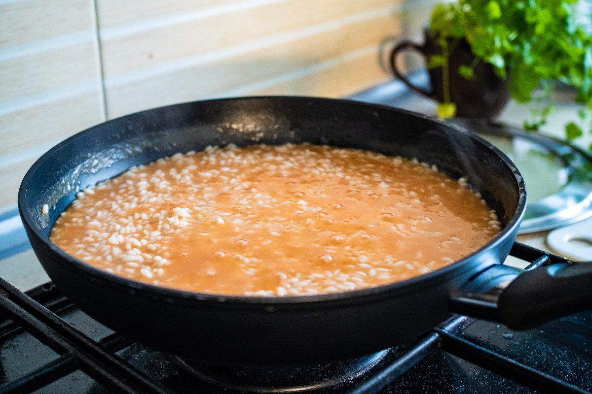 Padella con riso al pomodoro in cottura