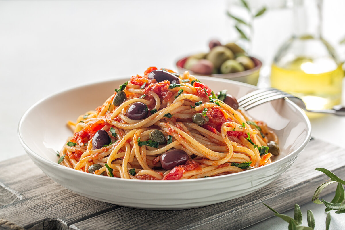 Piatto di spaghetti con olive, pomodoro, prezzemolo
