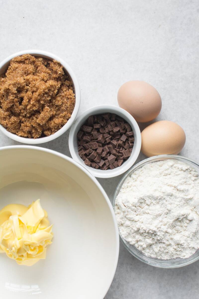 Vista dall'alto ingredienti blondies: zucchero, cioccolato, farina, uova e burro
