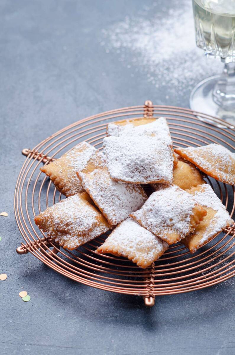 Ravioli dolci fritti cosparsi di zucchero a velo su gratella