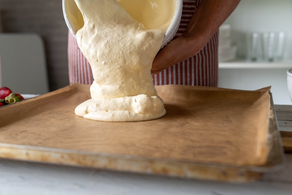 Impasto non lievitato che viene versato su leccarda rivestita di carta forno