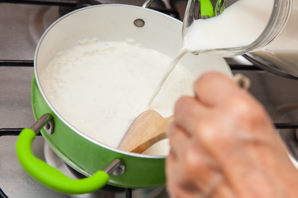 Aggiunta latte in pentola per preparazione budino di riso