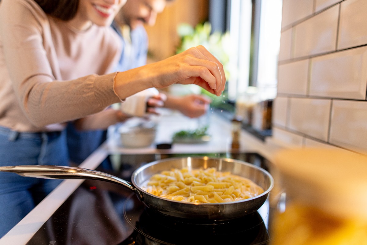 Cucinare un piatto di pasta utilizzando un piano a induzione.