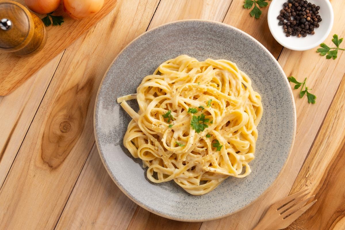 Vista dall'alto piatto di pasta tipo fettuccine condite con burro e grana