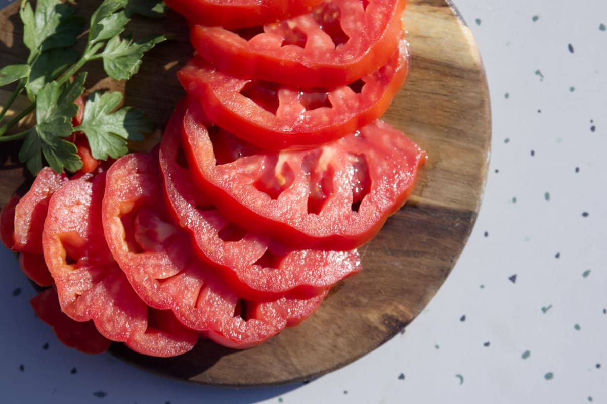 Tagliere di legno con pomodori a fette