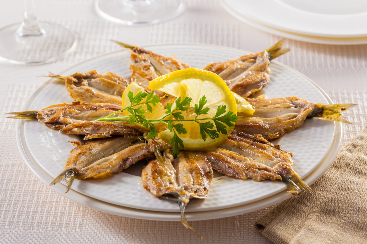 Piatto di alici fritte condite alla scapece con fetta di limone al centro