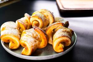 Piatto con croissant di pasta sfoglia fatti in casa spolverizzati con zucchero a velo