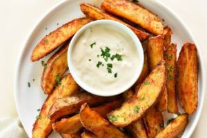 Chips di patate in un piatto bianco con salsa al centro