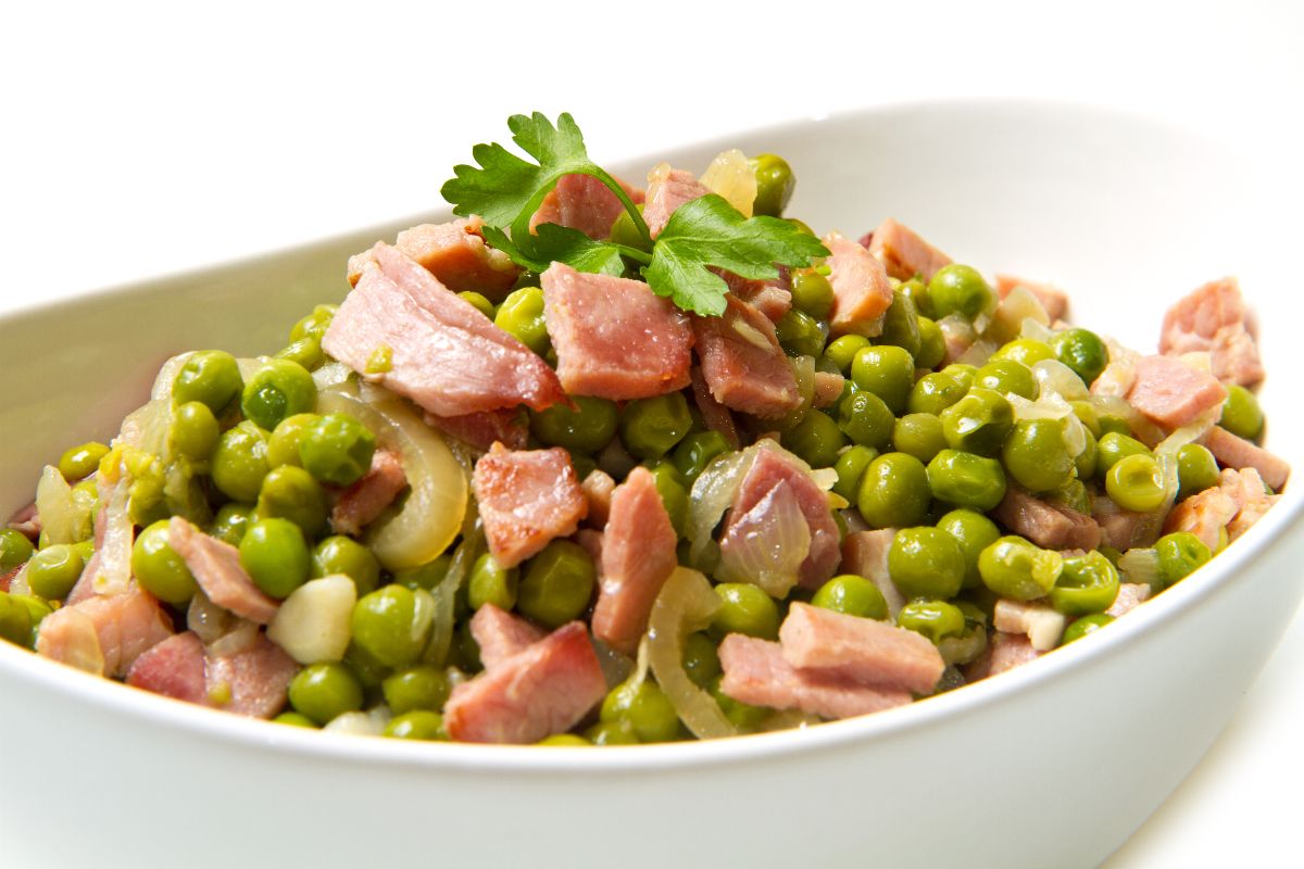 Ciotola con piselli cotti con pancetta e cipolla