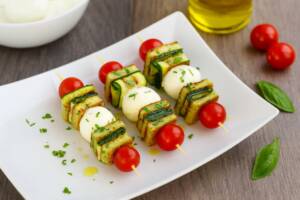 Piatto con spiedini di frittata, zucchine, pomodorini e mozzarella