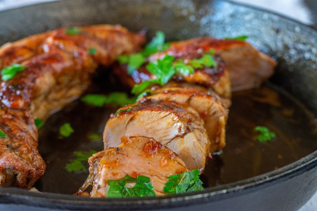 Piatto con filetti di maiale cotto alla birra tagliato a fette