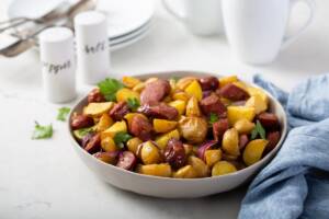 Piatto con patate a dadini e würstel a fette cotti in padella