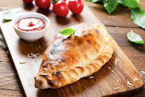 Lievitato tipo calzone chiamato cuddurune su tagliere di legno