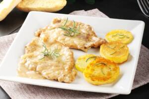 Piatto con scaloppine cotte in padella con contorno di patate