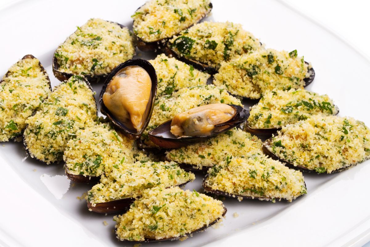 Piatto di cozze gratinate con pane, formaggio e prezzemolo