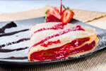 Crepes farcite con marmellata di fragole e decorate con zucchero a velo
