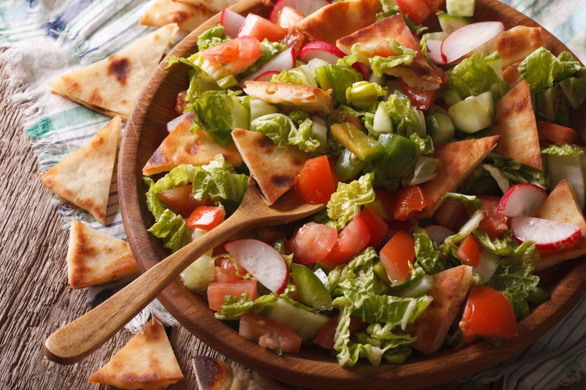 Piatto con insalata, pomodori, cetrioli e pane pita tostato