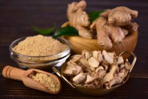 Zenzero fresco, in polvere ed essiccato su piano di legno