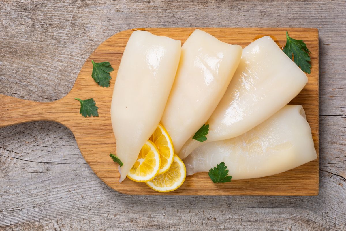 Totani puliti su tagliere di legno con fettine di limone