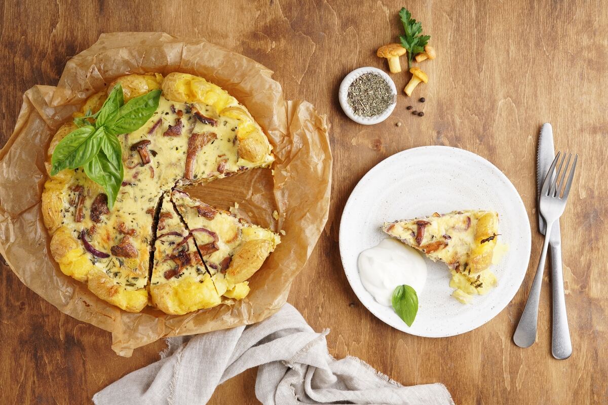 Vista dall'alto fetta di torta salata funghi e patate tagliata da torta intera