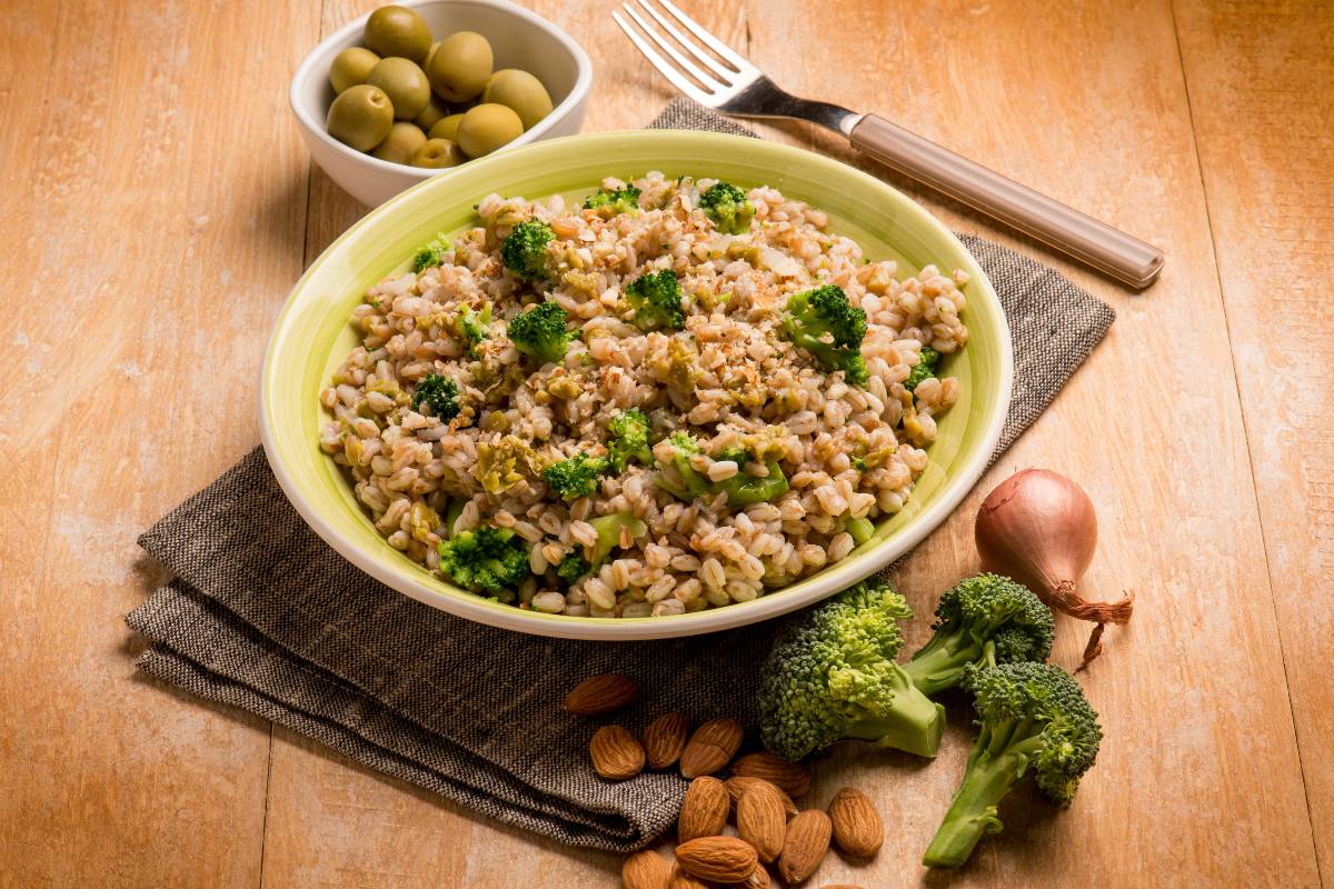 Piatto con insalata di farro con broccoli, mandorle e olive