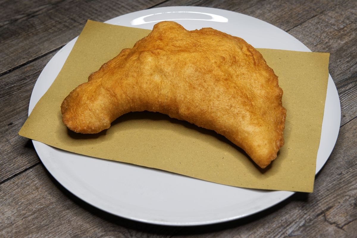 Pizza fritta con carta paglia su piatto