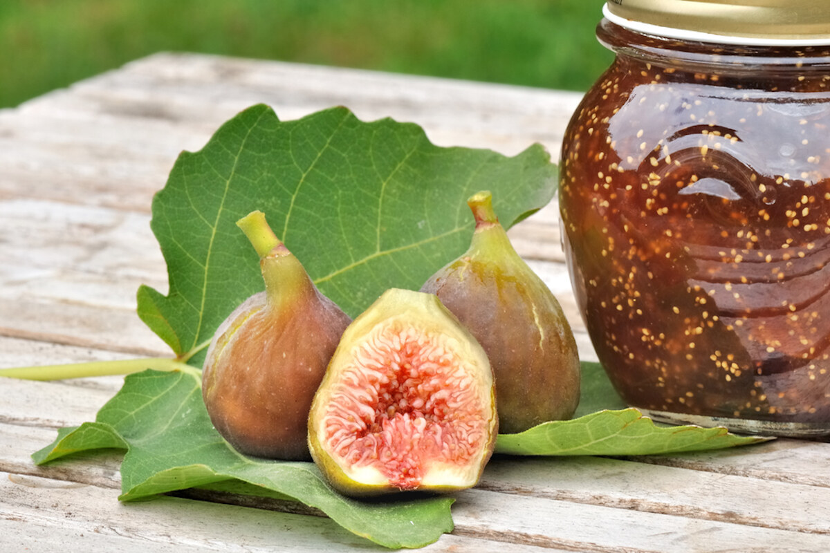 Vasetto di marmellata di fichi su tavolo di legno con fichi freschi