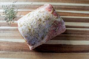 Arista di maiale da cuocere con erbe aromatiche sulla superficie