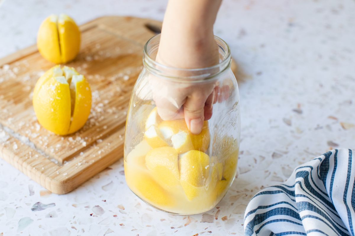 Limoni con sale messi in un barattolo di vetro e schiacciati con la mano