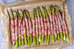 Vista dall'alto asparagi avvolti singolarmente nelle fettine di bacon e cotti al forno