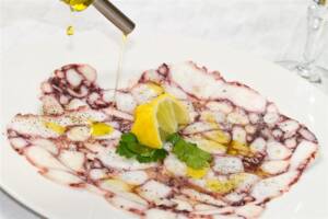 Fettine di carpaccio di polpo con limone, prezzemolo, olio e pepe