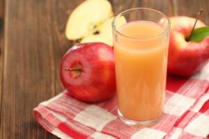 Bicchiere di succo di mela con mele fresche vicino