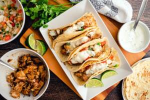 Vista dall'alto tacos di pollo su piatto con verdure e salsa
