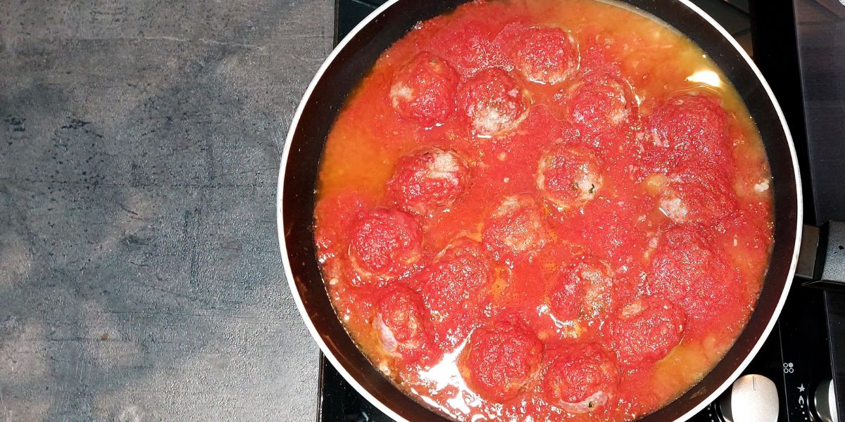 Add tomato sauce to meatballs
