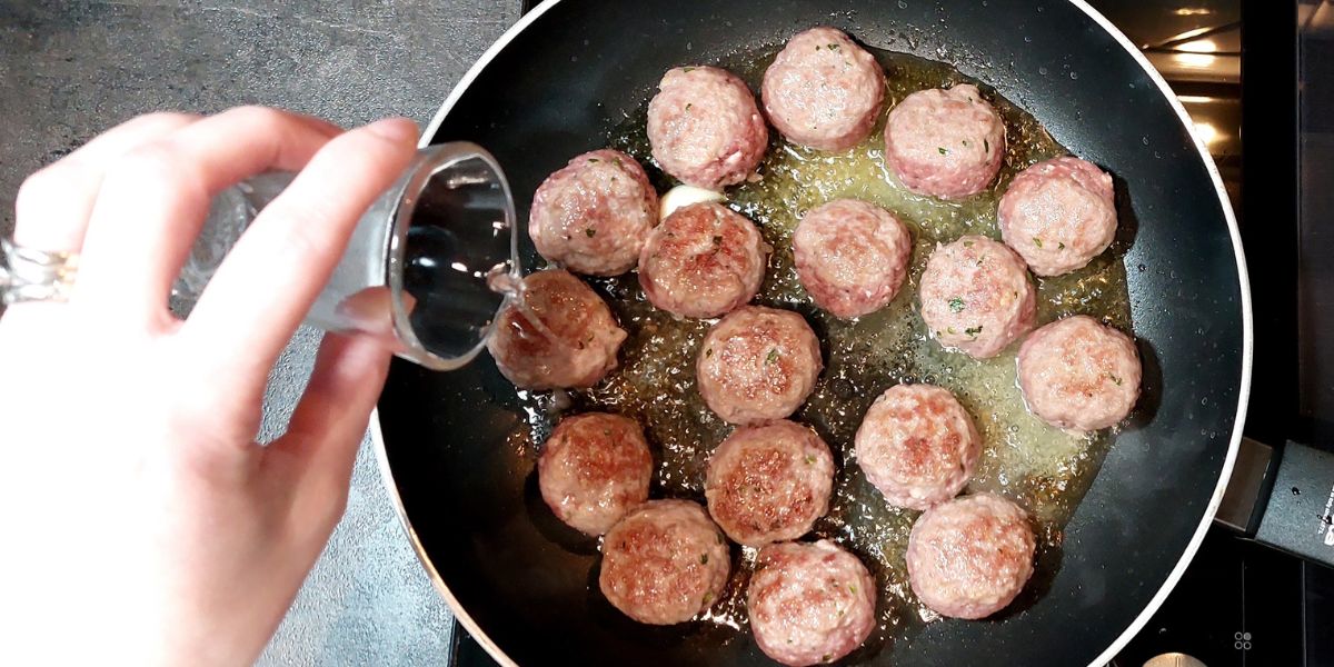 Deglaze meatballs with sauce with white wine and finish cooking